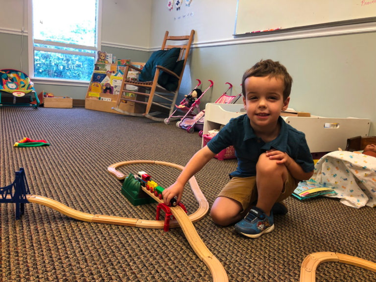 2022 photo of child playing with a toy train in the nursery